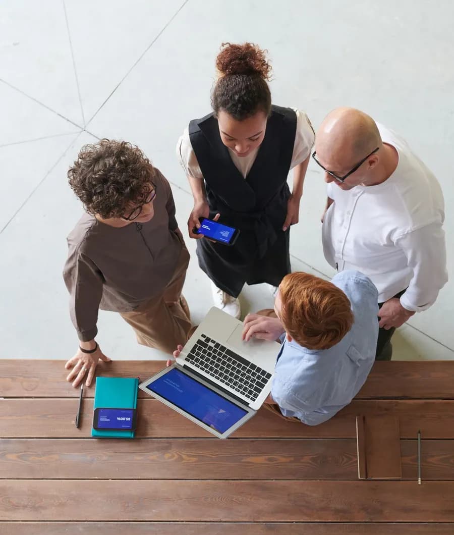 A product team reviewing an early build together on a laptop and phone